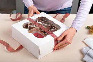 Gingerbread Prints: Process of packing confectionery gift box. Cookies in cardboard box