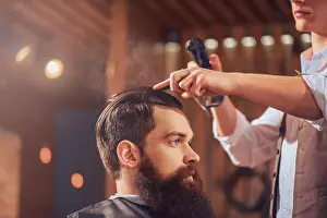 Concentrated Prints: Professional barber styling hair of his client