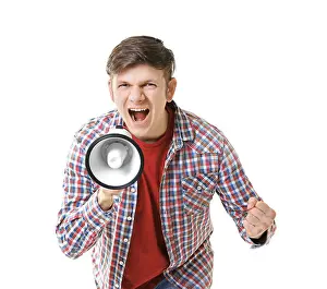 Megaphone Prints: Protesting young man shouting into megaphone on light background