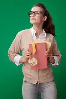 Educate Prints: proud modern student woman with books and medal looking at copy space on green background