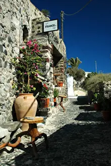 Cyclades Prints: Quaint village street with a cafe in Pyrgos on the Greek island of Santorini in the Aegean Sea
