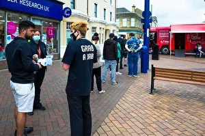 Tops Prints: A queue of people awaiting Covid 19 vaccinations at a temporary facility in a red bus at Redcar cleveland helpers