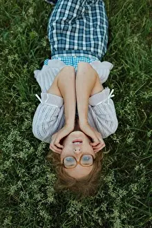 Kind Prints: Quirky woman with poor eyesight lying in the grass wearing glasses