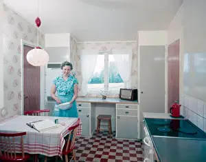 At Home Prints: Radio listeners in the past. A woman in the kitchen is whipping up something in a bowl at the kitchen table