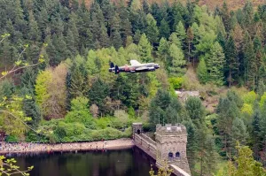 Over Water Prints: RAF Avro Lancaster bomber plane PA474 commemorative Dambusters pass down the Derwent Valley and over the dam