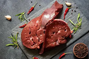 Fillet Prints: Raw Beef liver meat on stone board with thyme and black peppers, cattle giblets
