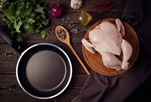 Raw fresh chicken, spices and herbs, frying pan, on a wooden table, top view, no people, toned