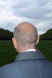 Forties Prints: Rear view portrait of a bald middle aged man looking far in the woods