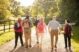 View From Behind Prints: Rear View Of Senior Friends Hiking In Countryside