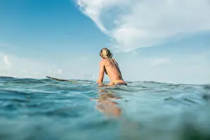 Surfboard Prints: rear view of shirtless male surfer swimming on surfing board in ocean at Nusa Dua Beach