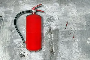 Extinguish Prints: Red fire extinguisher on concrete wall closeup