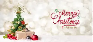 Red Merry Christmas and happy new year handwriting with xmas tree and gift box at blur bokeh light background