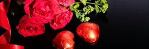 Valentines Day Prints: Red roses bouquet and heart-shaped chocolates, red ribbon on a black background