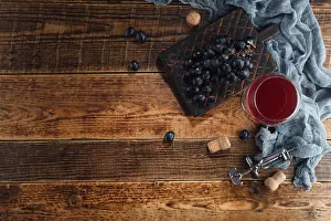 Tasting Prints: Red wine in a glass goblet with grapes and a vintage corkscrew on a wooden background