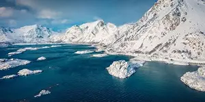 Nordland Prints: Red wooden house on the cliff. Dramatic winter view from flying drone of Sandvika bay