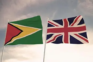 Guyana Prints: Relations between Guyana and United Kingdom UK symbolized by two flags waving against a cloudy sky