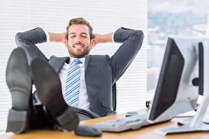 Eyes Closed Prints: Relaxed businessman sitting with legs on desk