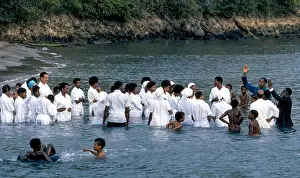 Rituals Prints: Religious participants dressed in white line up for full-immersion baptism in the water off Martinique