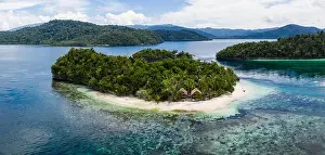A remote limestone island is surrounded by healthy reef in Raja Ampat, Indonesia. This diverse region is known as the heart of the Coral Triangle