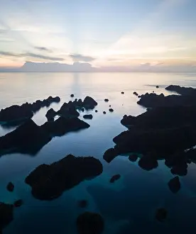 Remote limestone islands form a maze in a tropical lagoon in Raja Ampat, Indonesia. This diverse region is known as the heart of the Coral Triangle