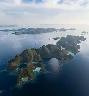 Remote limestone islands in Raja Ampat, Indonesia, are surrounded by healthy coral reefs. This biodiverse region is known for its marine biodiversity