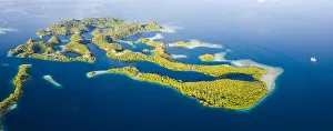 Remote limestone islands rise from the stunning seascape in Raja Ampat, Indonesia. This diverse region is known as the heart of the Coral Triangle
