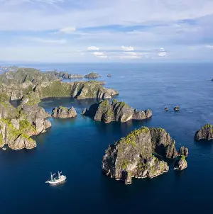 Remote limestone islands rise from the stunning seascape in Raja Ampat, Indonesia. This diverse region is known as the heart of the Coral Triangle