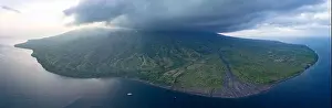 The remote, volcanic island of Sangeang rises from the seascape near Komodo National Park, Indonesia. This island is known for its black sand habitat