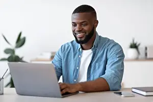 Free Space Prints: Remote Work. Handsome Black Freelancer Guy Working On Laptop At Home Office