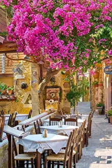 Restaurant at Chania Old Town, blooming bougainvillea flowers, Crete Island, Greece