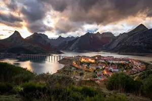 Flowing Water Prints: Riano cityscape at sunset with mountain range landscape during Autumn in Picos de Europa National Park