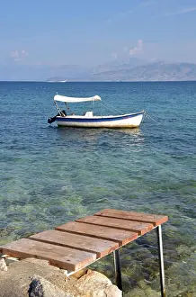 Distressed Prints: a rickety old pier or jetty in the Mediterranean sea off of corfu with the mountains of Albania