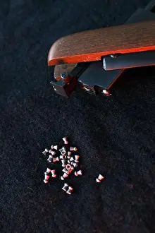 Trigger Prints: Rifle gun break in two with air pellets for hunting on cloth dark background with red light close up