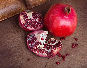 Pomegranate Prints: Ripe open pomegranate on wooden background