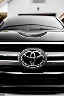 Manufacturer Prints: RIVNE, UKRAINE - JULY 10, 2021: Close up of Toyota car logo on a black Toyota car