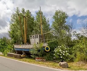 roadside scenery showing a rundown fishing cutter seen at Varel in East Frisia, Germany