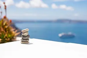 Cairn Prints: Rock zen pyramid of stones pebbles on the background of the sea and boat