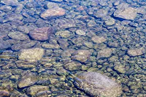 Calming Prints: Rocks visible below the clear water of a shallow area of a river