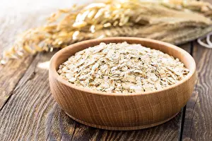 Dietary Prints: Rolled oat flakes in a wooden bowl and oat stalks