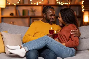 Joking Prints: Romantic black couple cuddling on couch at home