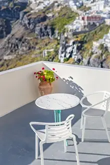 Romantic two chairs and a table on the terrace, Santorini island Greece. Summer vibes with white architecture and sea view. Luxury travel background