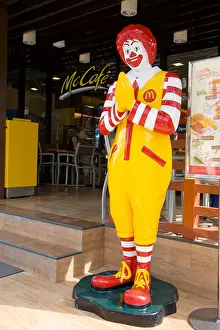 Ronald McDonald outside Thai McCafe in Thai greeting pose