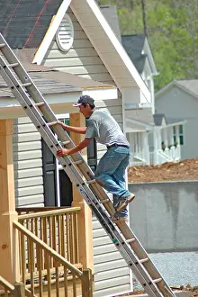 Floors Prints: Roofers installing shingles on roofs outside of new home construction air nail guns with Mexican immigrants in Georgia