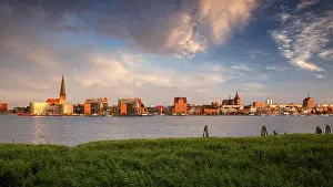 Rostock, Germany. Panoramic cityscape image of Rostock riverside with St. Peter's Church during summer sunset