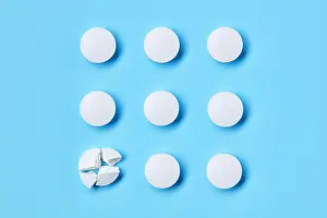 Pills Prints: Round white medical pills arranged in square order and one of them is crushed into four parts