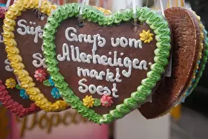 Gingerbread Prints: A row of colorful heart-shaped cookies with the words 'Grupp vom Allesheiligen Markt Söost' written on them