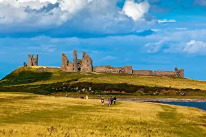 Walkers Prints: The ruins of Dunstanburgh Castle in Northumberland north east England UK seen from the coast path from Craster village