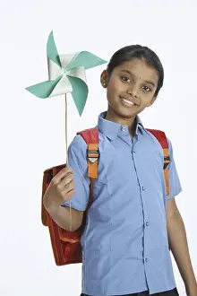 Schoolbag Prints: Rural girl carrying school bag on shoulder holding whirligig in left hands MR#743C