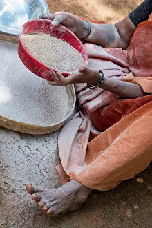 Saree Prints: Rural Indian village woman sifting Finger Millet flour / Ragi flour after grinding