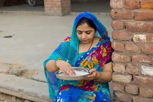 Saree Prints: Rural Indian woman cleaning rice by hand in plate do household work